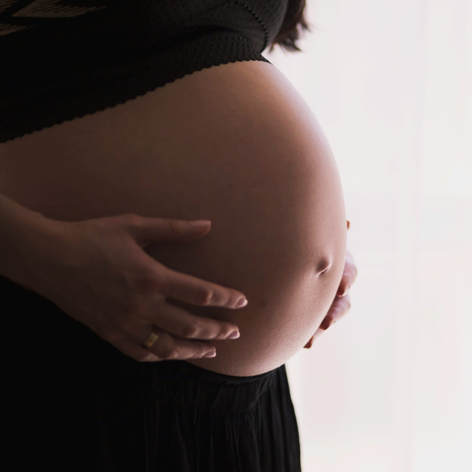 Mother holding her baby in a quiet moment of reflection, representing the emotional transition of matrescence